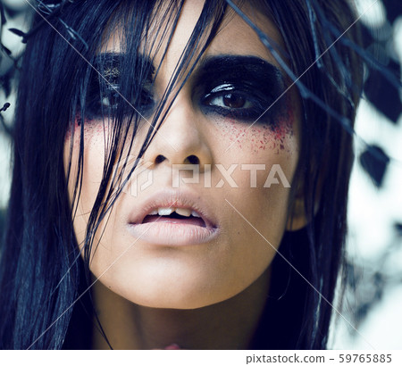 pretty brunette woman with make up like demon at halloween, closeup scary 59765885