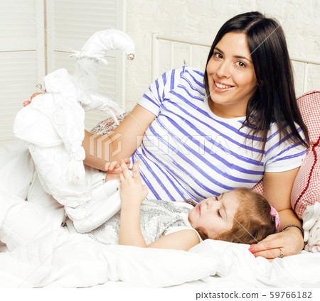 Portrait of mother and daughter laying in bed and smiling close up, lifestyle family people concept Portrait of mother and daughter laying in bed and smiling close up, lifestyle family people concept 59766182