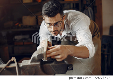 Handsome carpenter working with a wood Handsome carpenter working with a wood 59771372