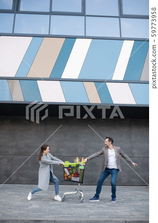 Husband and wife feeling happy spending weekend and buying foods together Husband and wife feeling happy spending weekend and buying foods together 59773958