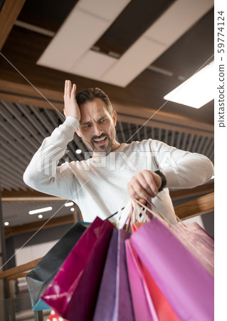 Bearded man feeling shocked while waiting for wife for too long 59774124