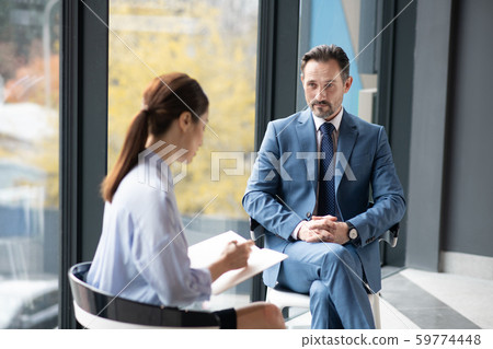 Young journalist speaking with businessman about his success story Young journalist speaking with businessman about his success story 59774448