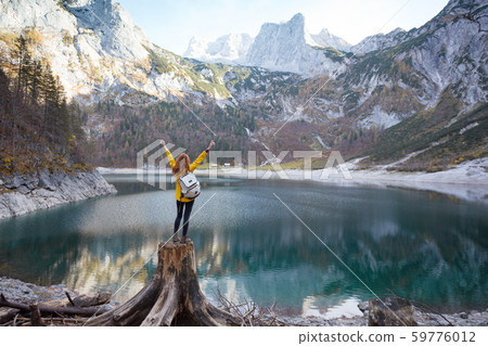 girl stands on the shore of a mountain lake girl stands on the shore of a mountain lake 59776012