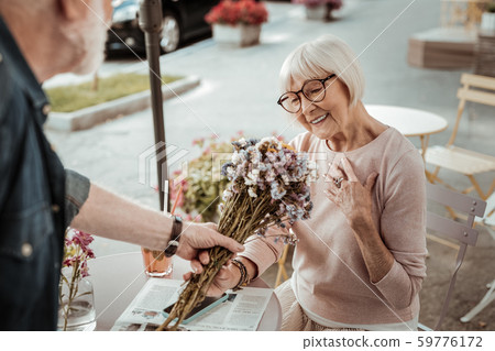 Nice joyful woman being happy to receive a bouquet Nice joyful woman being happy to receive a bouquet 59776172