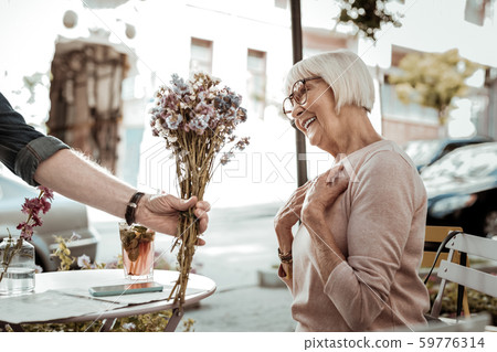 Joyful nice aged woman receiving beautiful flowers Joyful nice aged woman receiving beautiful flowers 59776314