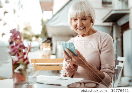 Delighted elderly woman using her new smartphone 59776421