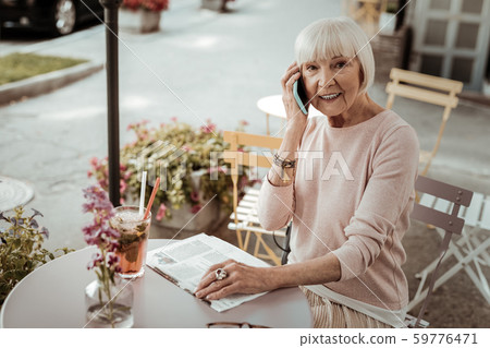 Joyful elderly woman making a phone call 59776471