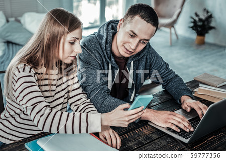 Nice positive man looking at her girlfriends smartphone 59777356