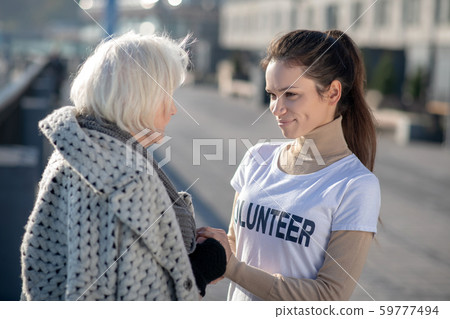 Grey-haired homeless pensioner talking to volunteer in the street Grey-haired homeless pensioner talking to volunteer in the street 59777494