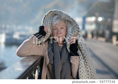 Poor homeless woman feeling very cold thus putting coat on head Poor homeless woman feeling very cold thus putting coat on head 59777538