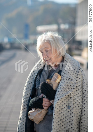 Grey-haired homeless pensioner having only bread to eat Grey-haired homeless pensioner having only bread to eat 59777600