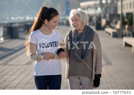 Dark-haired kind volunteer listening to poor homeless woman Dark-haired kind volunteer listening to poor homeless woman 59777633