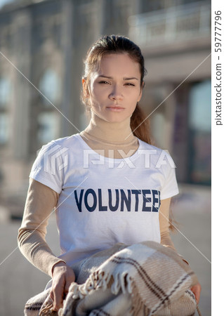 Dark-haired woman wearing white t-shirt working as volunteer Dark-haired woman wearing white t-shirt working as volunteer 59777796