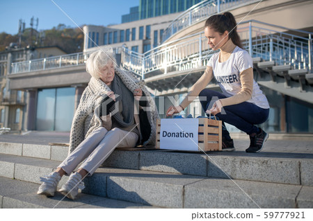 Volunteer bringing donation for poor homeless woman 59777921