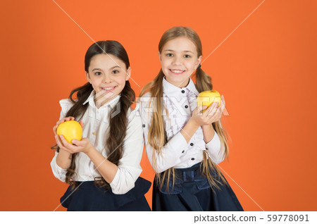 Using nutrition first. Cute schoolgirls holding Using nutrition first. Cute schoolgirls holding 59778091