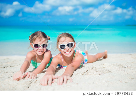 Adorable little girls walking on the beach 59778458