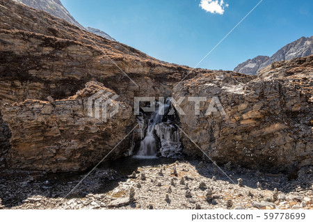 Cliff rock with waterfall flowing in stream 59778699