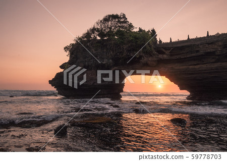 Sunset through of rocky cliff on seashore at Sunset through of rocky cliff on seashore at 59778703