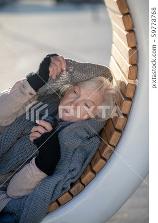 Homeless pensioner wearing grey sweater while feeling cold Homeless pensioner wearing grey sweater while feeling cold 59778768
