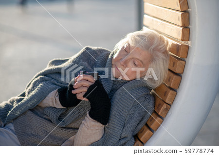 Woman drinking tea while spending day outside Woman drinking tea while spending day outside 59778774