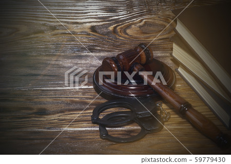 Handcuffs and a wooden gavel in front of manila 59779430