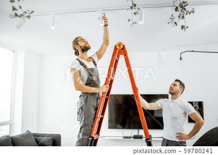 Men installing lights at home Men installing lights at home 59780241