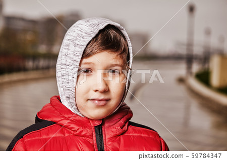 A boy of seven years in warm clothes on the street A boy of seven years in warm clothes on the street 59784347