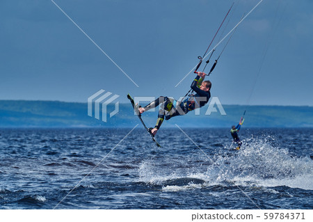 A male kiter slides on the surface of the water. A male kiter slides on the surface of the water. 59784371