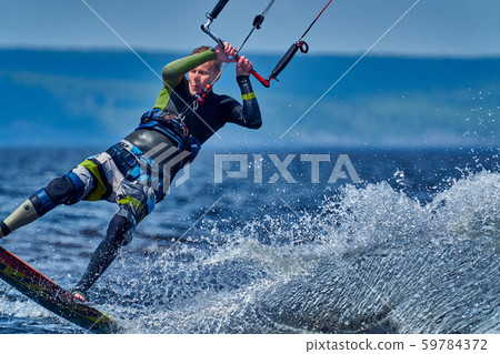 A male kiter slides on the surface of the water. A male kiter slides on the surface of the water. 59784372