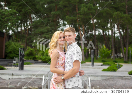 A loving young couple is hugging in a green park. A loving young couple is hugging in a green park. 59784559