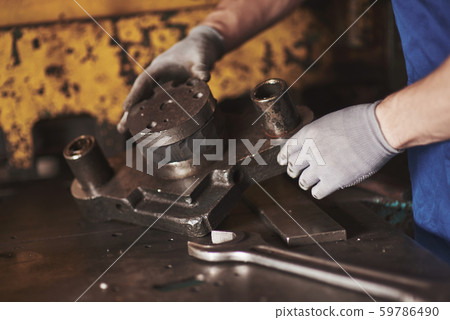 Strong hands hold the steel part. Strong hands hold the steel part. 59786490