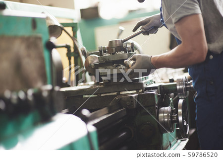 Strong hands hold the steel part. In the old factory. Strong hands hold the steel part. In the old factory. 59786520