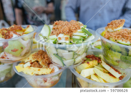 Sour crispy mangoes with spicy salt dips on top 59786626
