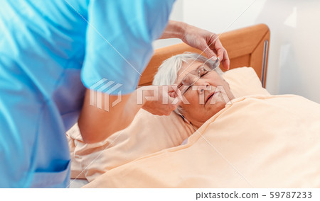 Nurse taking care of sleeping senior woman in the nursing home 59787233