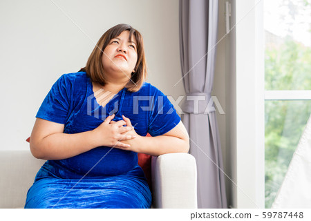 Overweight Asian women are sitting on the sofa in 59787448