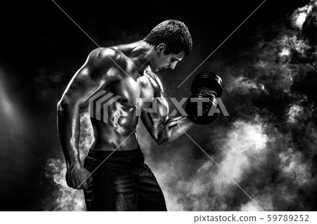 Concentrated muscular man doing exercise with dumbbell 59789252