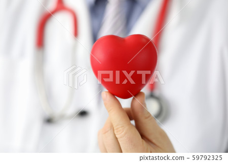 Doctor hold in hand red toy hert against hospital 59792325