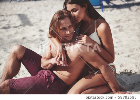 A romantic couple on the beach in a swimsuit, beautiful sexy young people A romantic couple on the beach in a swimsuit, beautiful sexy young people 59792583