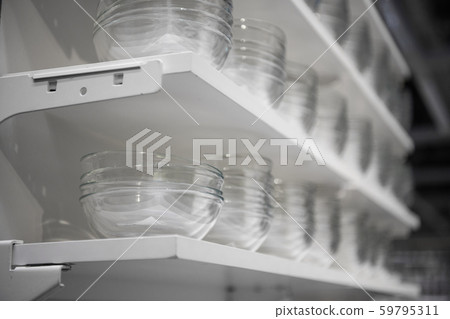 Row of empty white glass bowls on a shelf. Glass bowls at kitchenware shop. 59795311