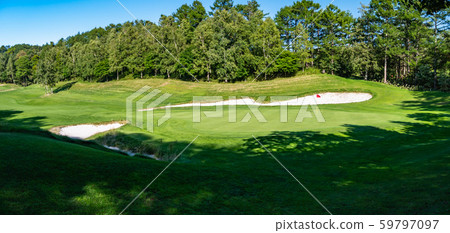 The putting green of the golf course and a panoramic view of the lush summer course. The putting green of the golf course and a panoramic view of the lush summer course. 59797097