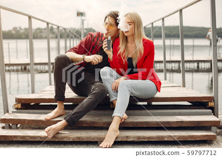 Stylish young couple with vape in a city Stylish young couple with vape in a city 59797712