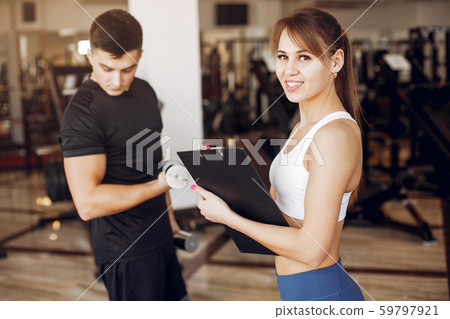 A beautiful sports couple is engaged in a gym A beautiful sports couple is engaged in a gym 59797921