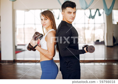 A beautiful sports couple is engaged in a gym A beautiful sports couple is engaged in a gym 59798018