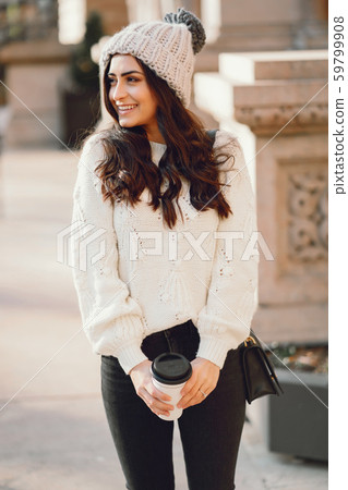 Cute brunette in a white sweater in a city 59799908