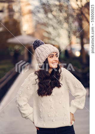 Cute brunette in a white sweater in a city Cute brunette in a white sweater in a city 59800025