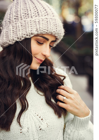 Cute brunette in a white sweater in a city Cute brunette in a white sweater in a city 59800077