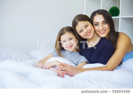 Happy family on the bed. Children with their mother in the bedroom. Happy family on the bed. Children with their mother in the bedroom. 59805499
