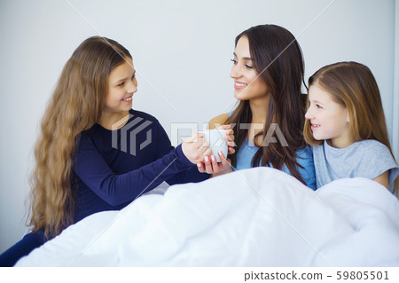 Happy family on the bed. Children with their mother in the bedroom. Happy family on the bed. Children with their mother in the bedroom. 59805501