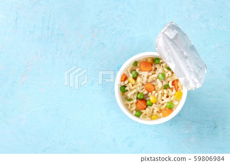 Ramen cup, instant noodles in a plastic cup, overhead shot on a blue background with a place for Ramen cup, instant noodles in a plastic cup, overhead shot on a blue background with a place for 59806984