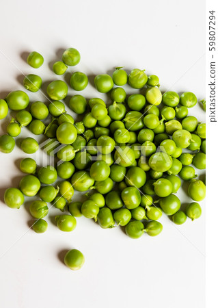 Green fresh scattered peas on a white background. Green fresh scattered peas on a white background. 59807294